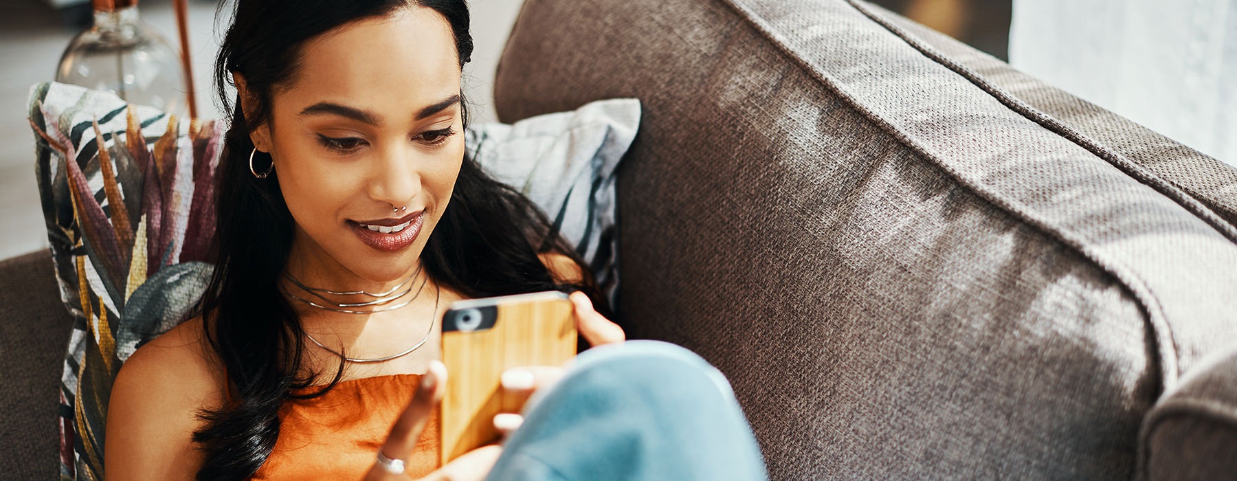 woman sitting in her living room on her phone